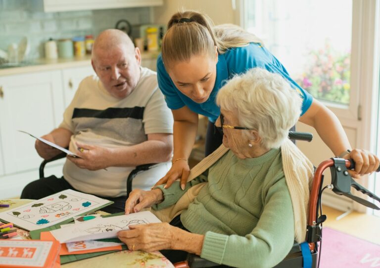 Social worker speaking with a resident at a kitchen table during a home visit